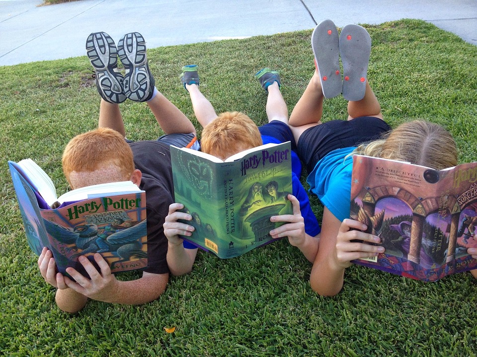 tres niños leyendo harry potter
